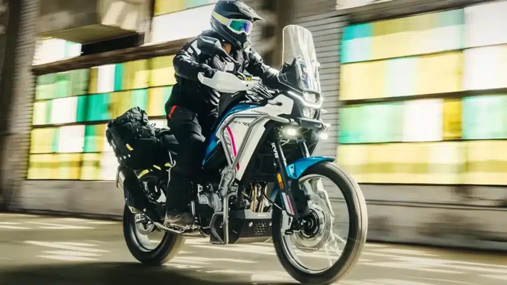 CFMOTO Ibex 450 com motociclista em movimento, vista de três quartos.